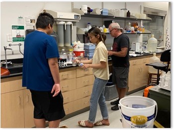 Photograph of Lala, Winner, and Scott Alexander working in a laboratory.